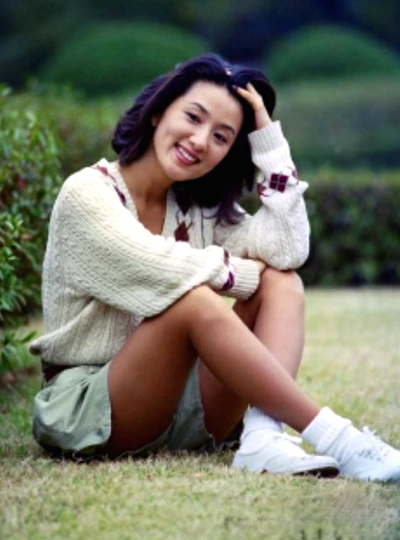 Kim Hee-ae sitting on the grass inside a park