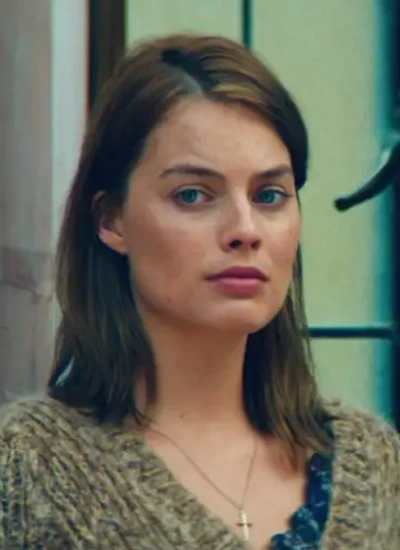 Margot Robbie with messy medium straight hair tucked behind her ears